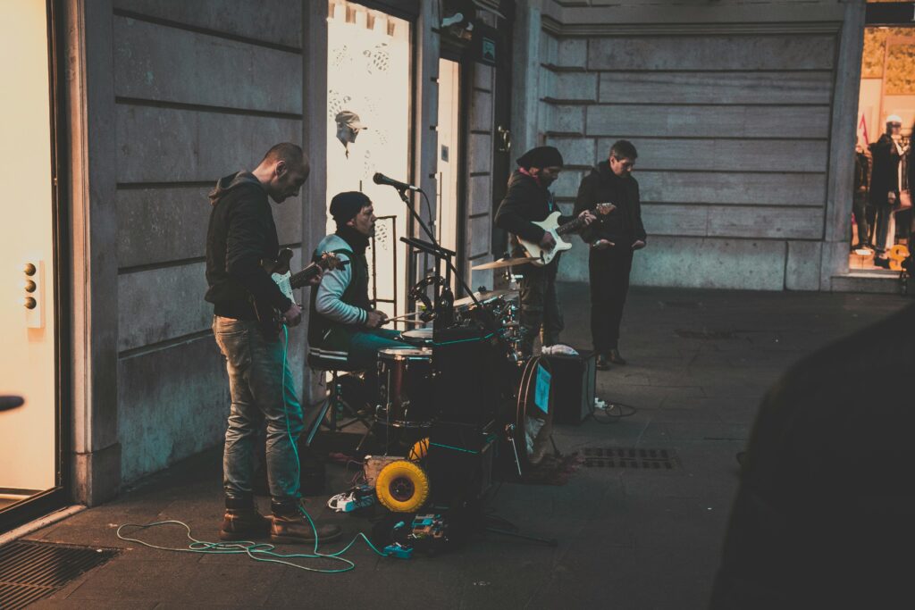 pexels photo 2064805 2064805 A group of street musicians performing with instruments on a city sidewalk during the evening.